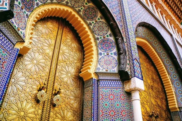 Moroccan architecture influencing Scandinavian design with intricate tilework and golden doors.